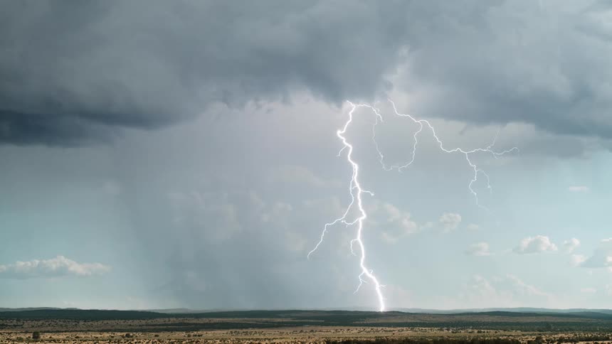 Cloudy sky with thunder from a storm above a field