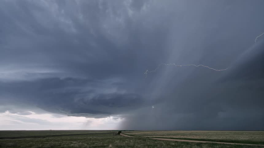 Greenish field in a cloudy sky with lightning