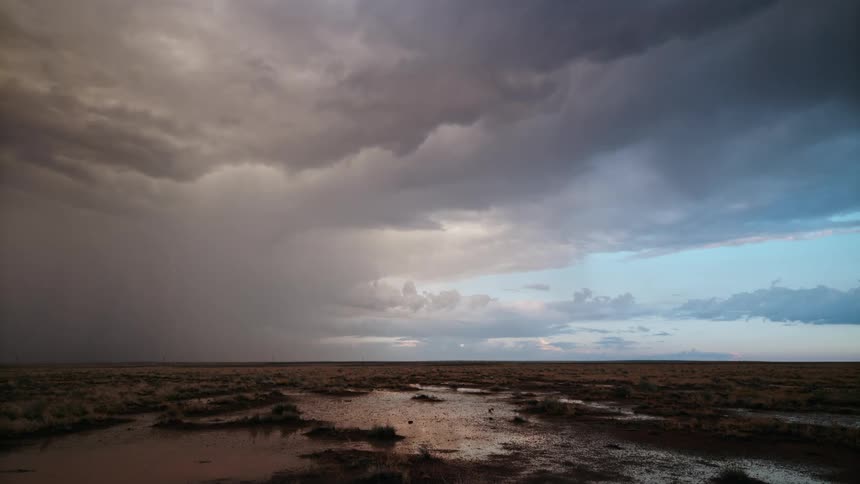 A dramatic thunderstorm with lightning strikes the plains in daylight