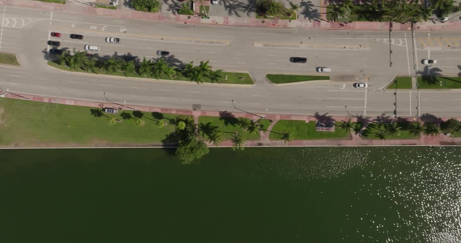 Aerial panorama of yachts moored in a harbor on the side of a highway in a metropolis with vehicle traffic
