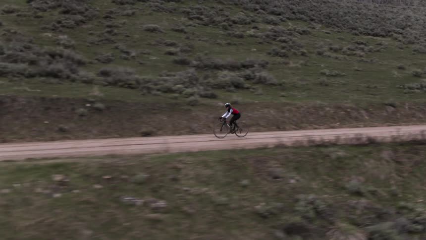Person riding bicycle on dirt road