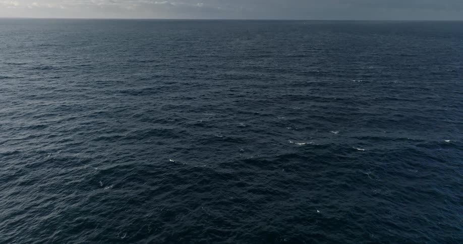 Small waves flow across the surface of the ocean on a cloudy day