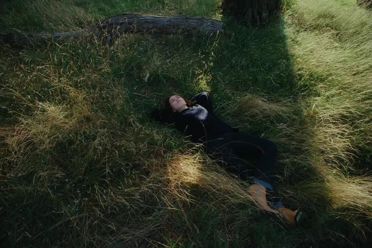 A young woman dieting on the grass in the shade of a tree