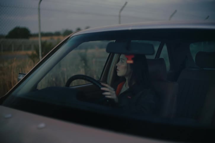 Woman getting into the car and placing her hands on the steering wheel