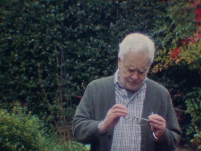 Elderly man taking off his prescription glasses and putting them back on