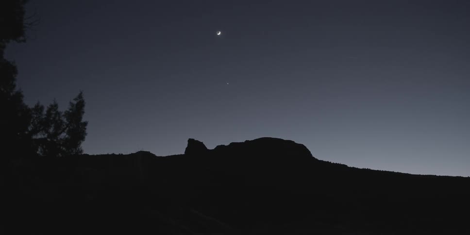 The silhouette of a hillside in the moonlight