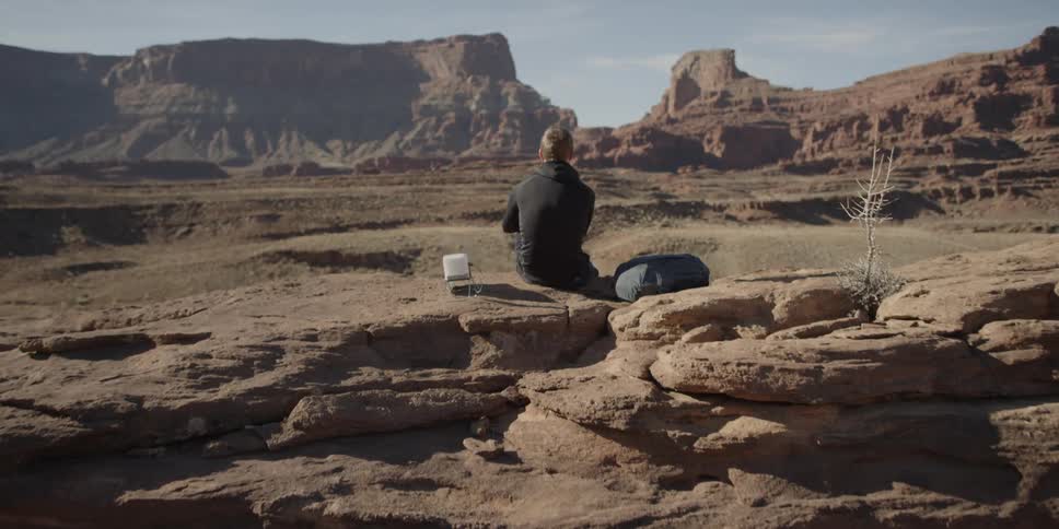 Man sitting and observing large rock formations in the distance