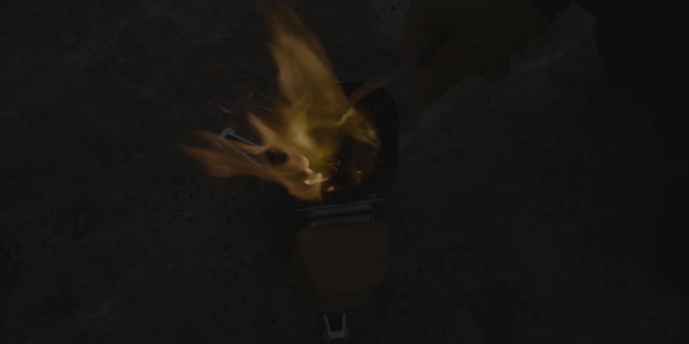 A small fire is burning in a dark area