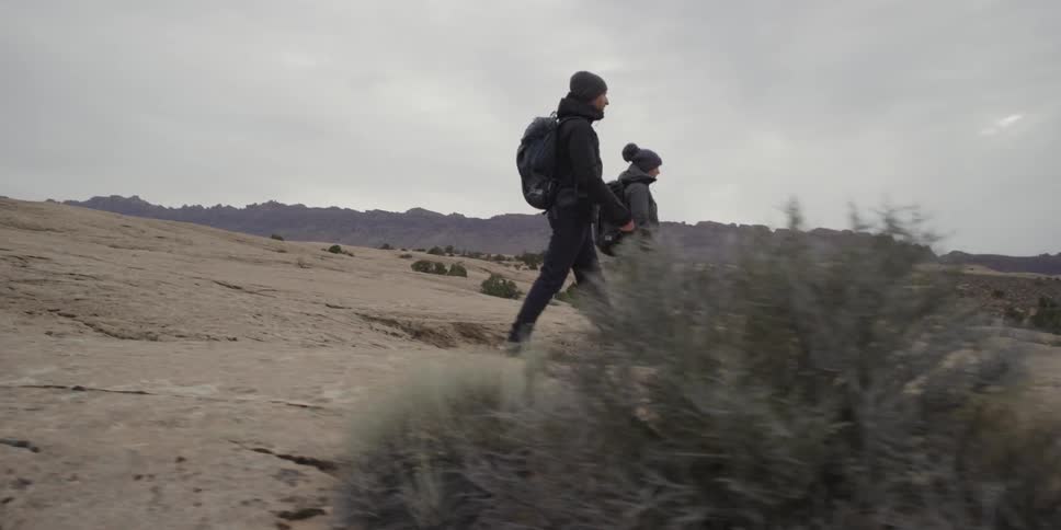 Hikers walk across a rocky surface