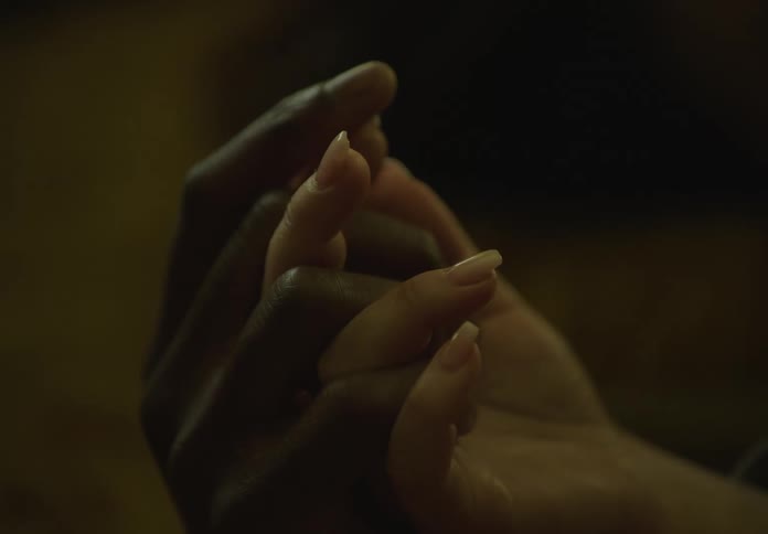 A black male hand holding a white female hand
