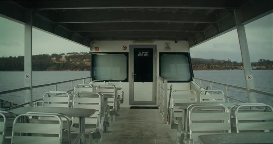 A ferry crosses a lake on a cloudy day