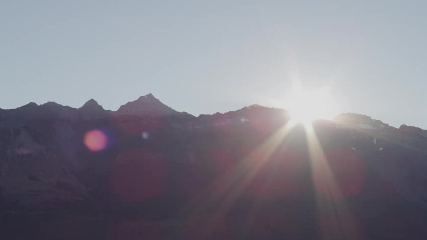 The sun rises behind the mountains