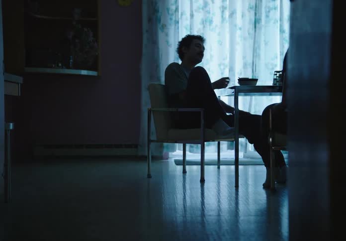 Man sitting and then a woman sitting next to him at a table