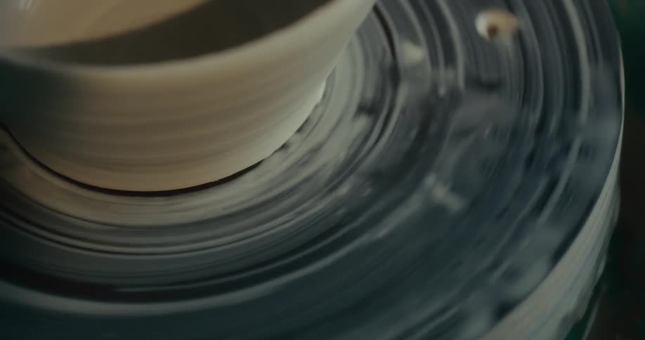 A spinning pottery wheel with a clay piece being shaped