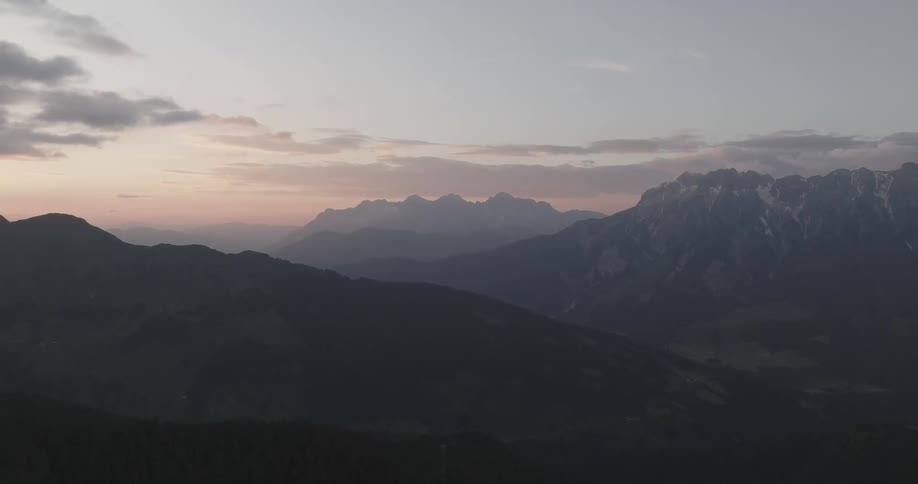 A mountain range at twilight with a pink and blue sky at either sunrise or sunset