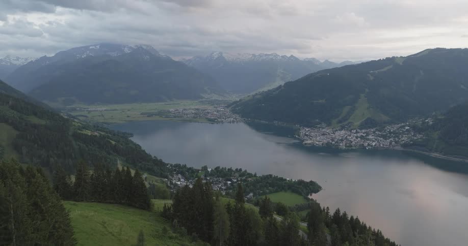 Mountainous valley with a lake in the center and a town in the distance