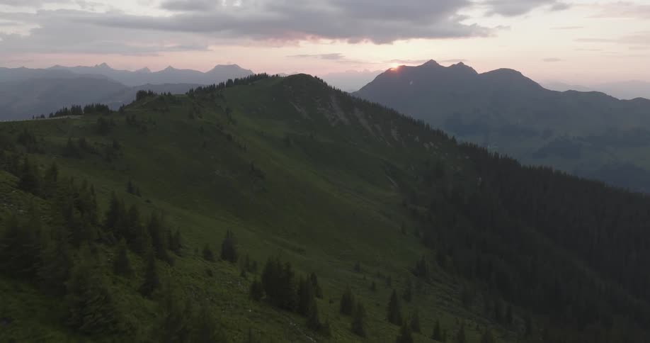 Aerial view of the sun setting over a mountainous landscape