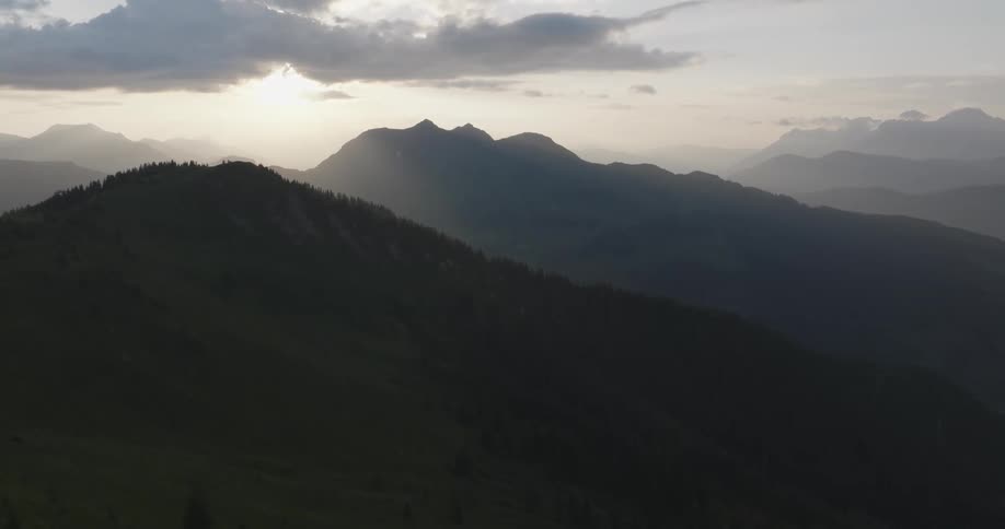 Mountain ranges silhouetted against a partially cloudy sky