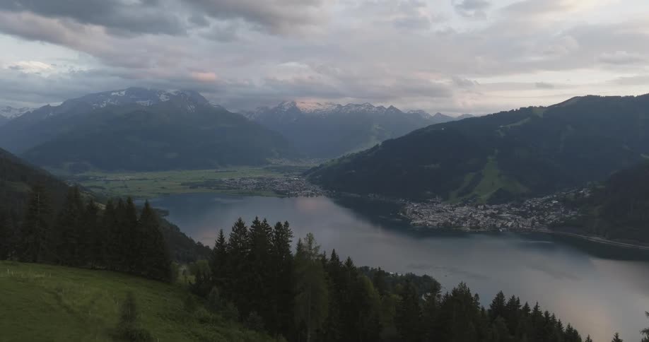 A town surrounded by a mountain sits on a lakeshore