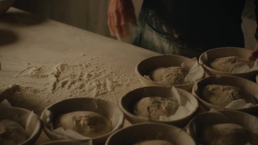 Person pouring powder from bowl onto a table