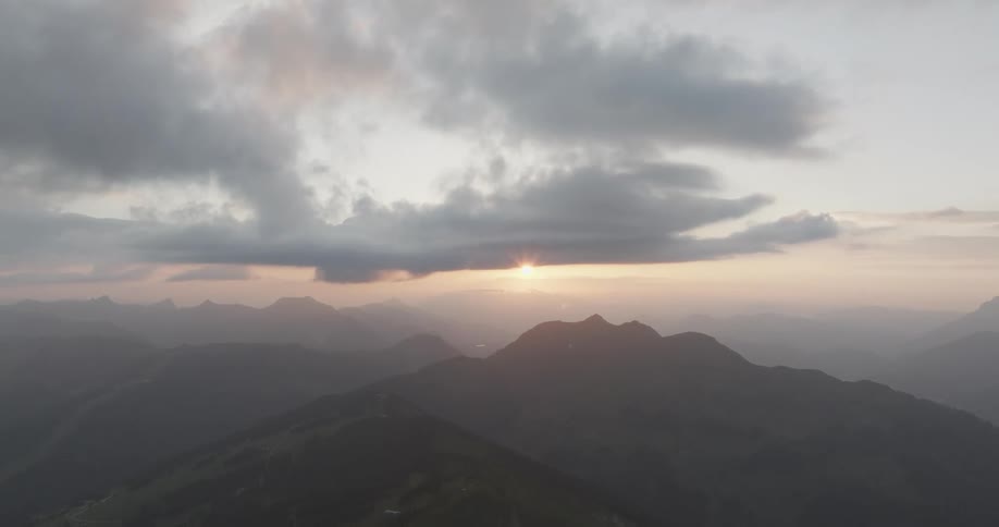 Panorama of mountain ranges with the sun on the horizon