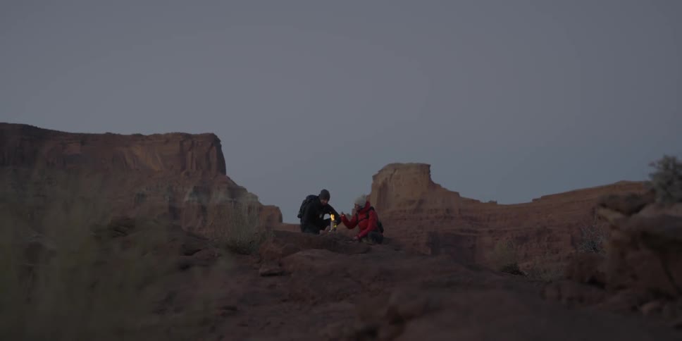 Two people sitting near a small fire