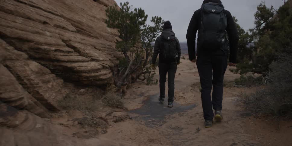 Two people hike through a valley
