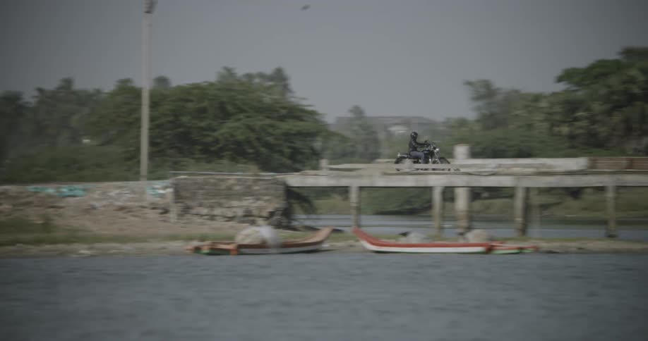 A biker is being filmed riding in the distance