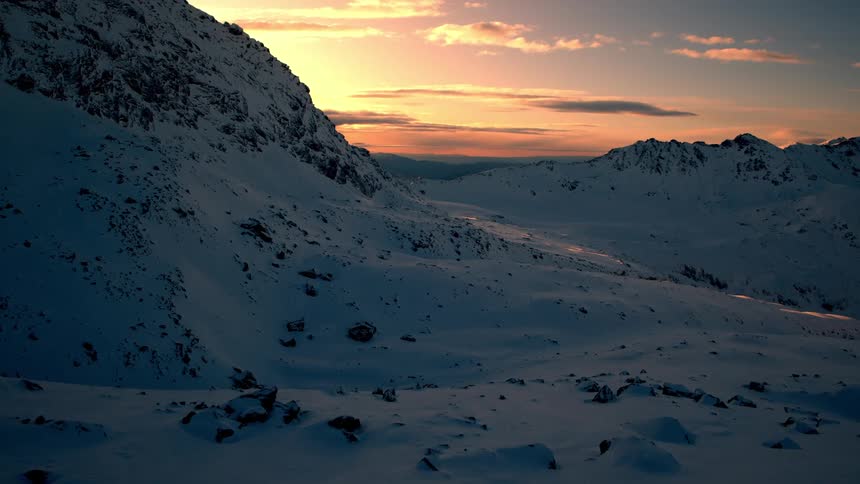 Snow covered mountains and plains at dusk