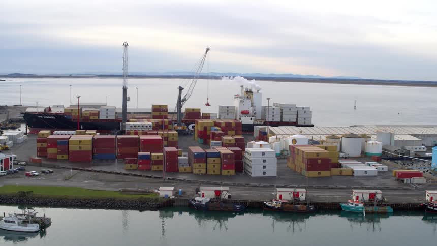 Harbor with several colorful containers stacked and cargo ships docked
