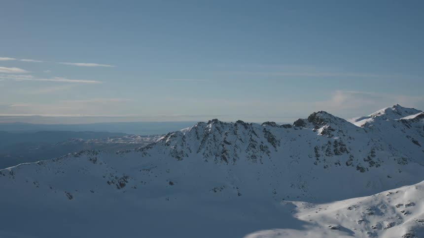 The large mountain range is covered with snow
