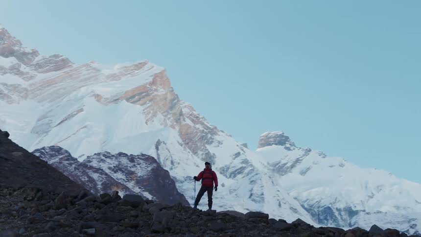 A man is standing on top of the mountain