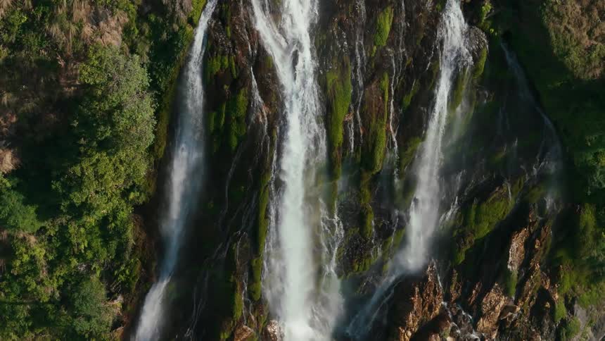 Large waterfalls tumble down the side of a mountain