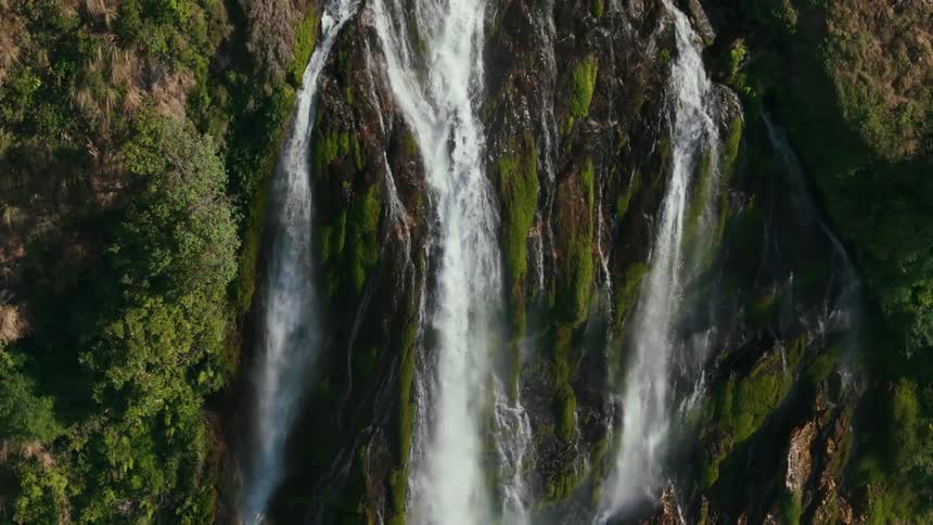 Multiple waterfalls cascading down a forested cliff
