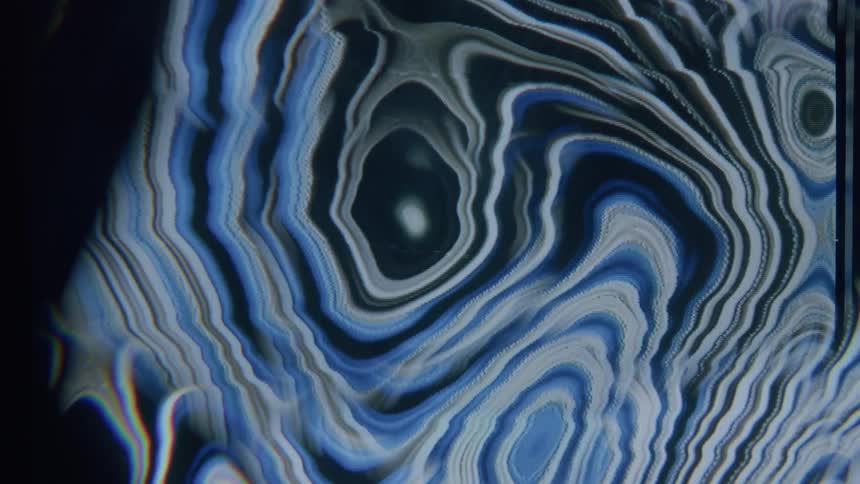 Strips in various colors flow and merge to create swirls and other shapes in a screensaver
