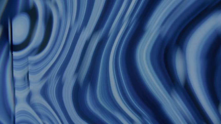 Blue liquid pools and forms waves as it moves