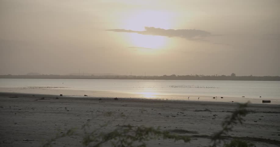 A beach at sunset on a cloudy day