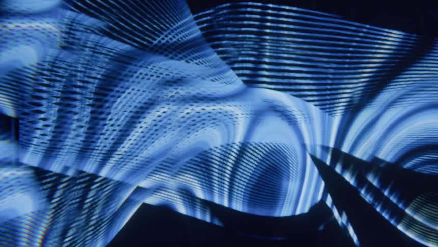 Lines of a screensaver flow and cross forming meshes and other patterns against a black background