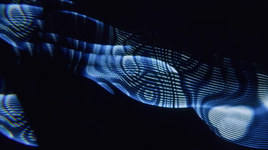 Projection of psychedelic blue lines against black background