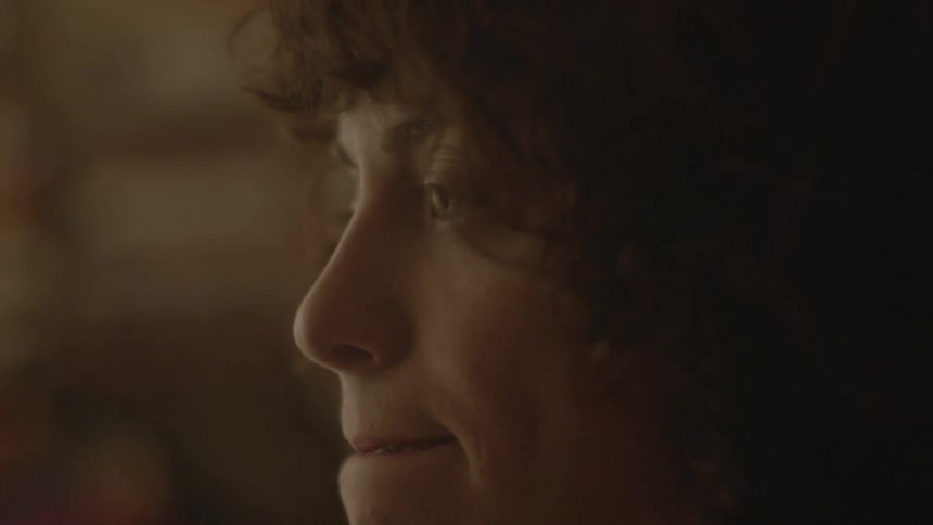 A woman looks ahead blinking