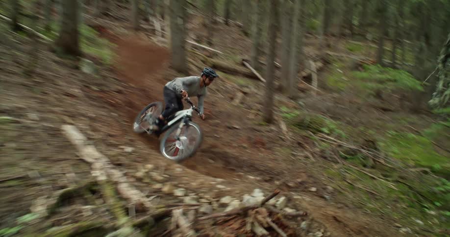 Mountain biker descends dynamic forest trail at high speed