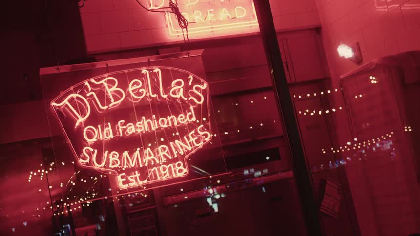 Storefront of a restaurant with a neon sign overhead