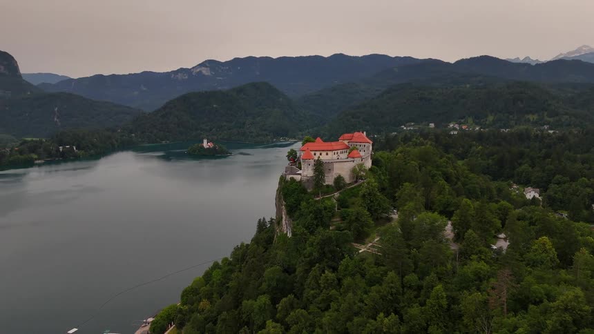 A large villa is on the mountain by the water