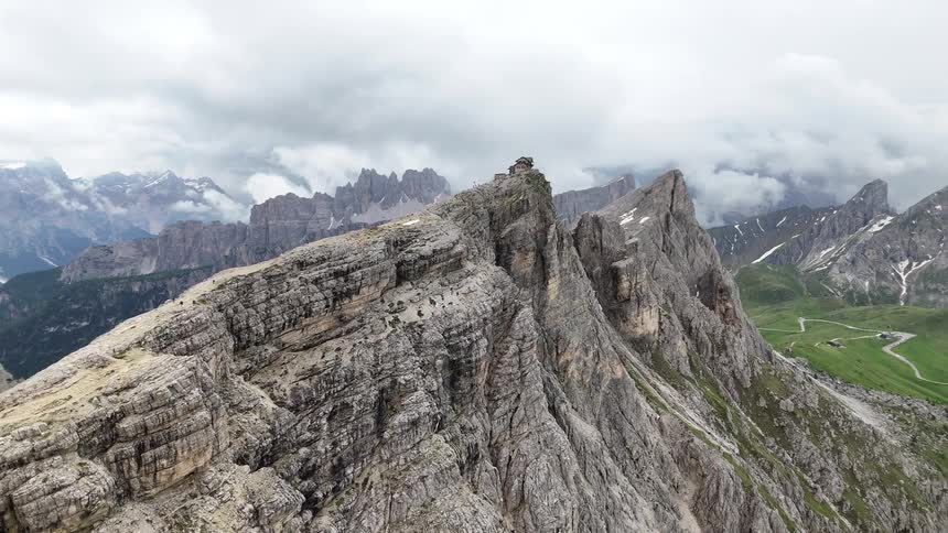 A rugged mountain peak crowned by a small structure