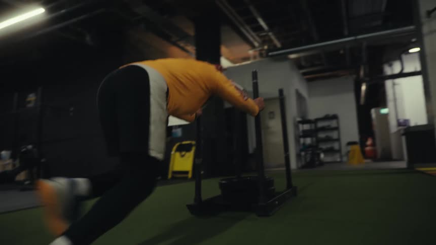 A man pushing some weights around in a gym