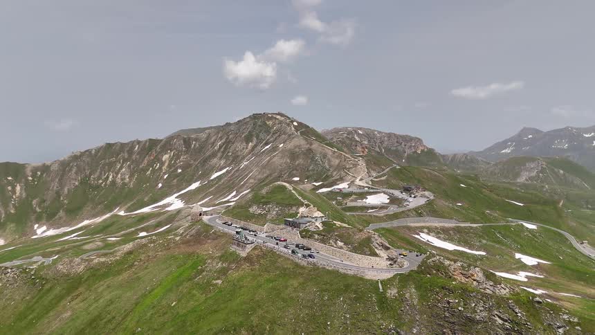 Winding road with vehicle traffic through a snowy mountain valley