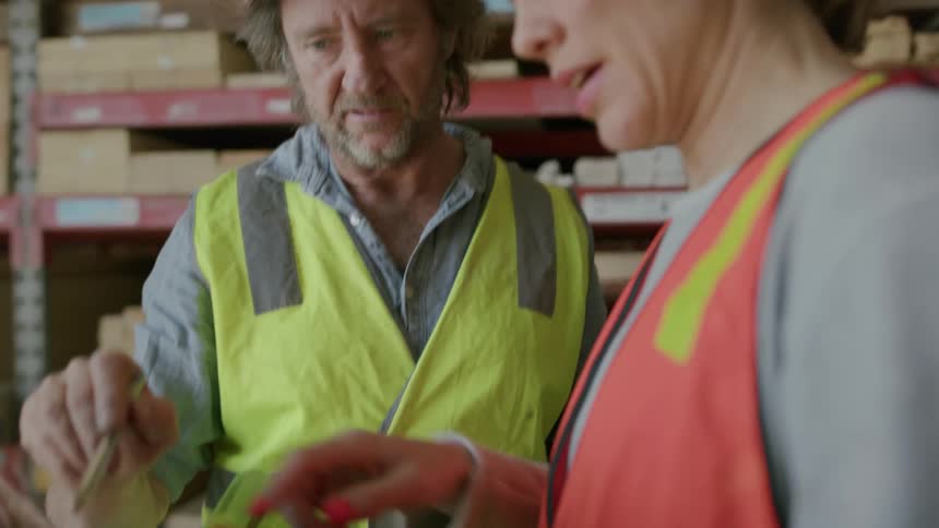 Portrait of two workers with one of them holding a laptop and talking