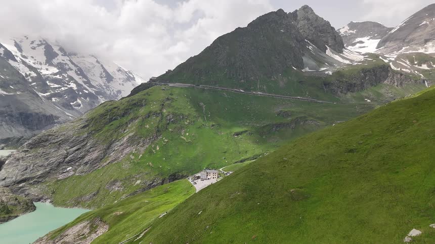 Aerial panorama of a mountain valley with a lake in the background on a cloudy day