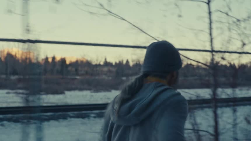 An old man runs down a snow covered path by a river
