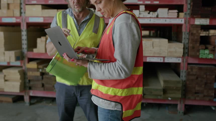 A man and woman talk in the lumber yard